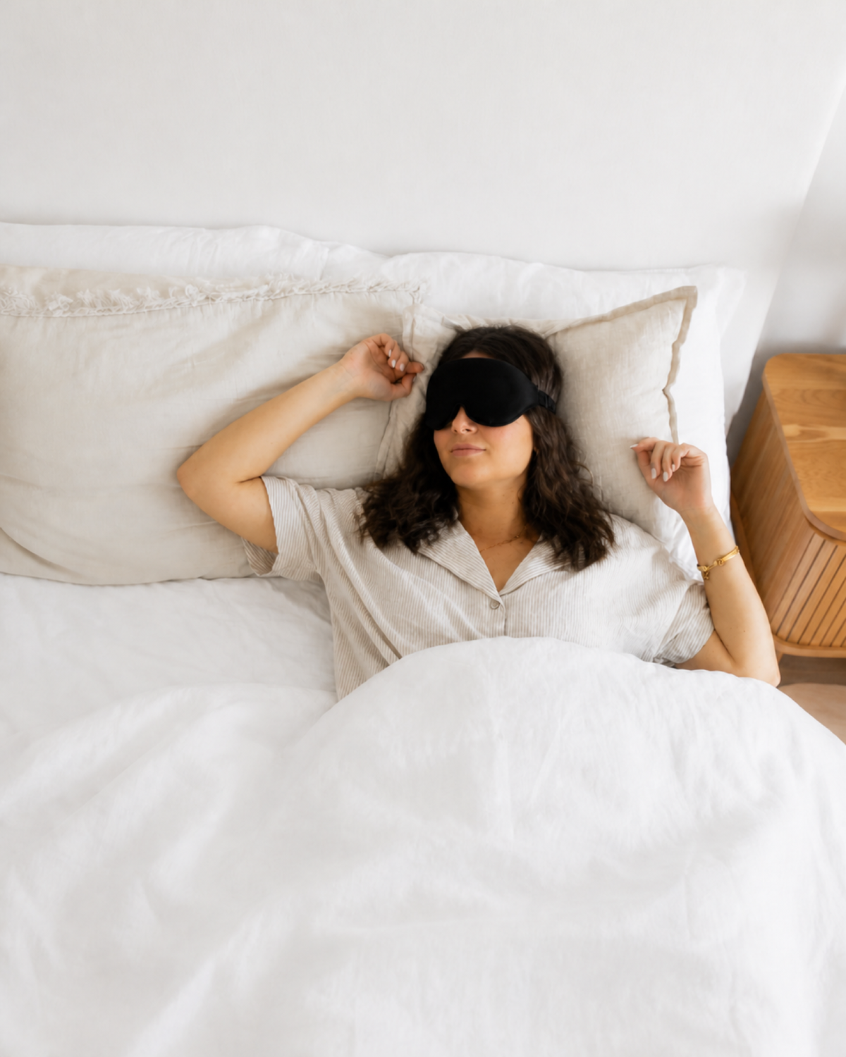 Woman sleeping on her back wearing the RestingBelly Sleep Mask