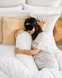 Woman resting with a pillow while wearing the RestingBelly Sleep Mask